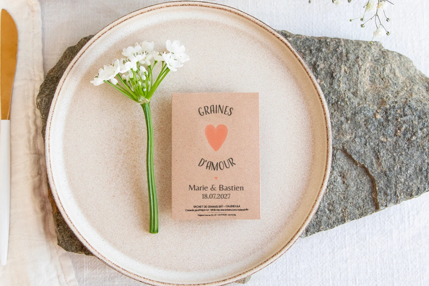 Sachet de graines cadeau invité mariage en kraft graines d'amour déposé dans une assiette sur une table de mariage